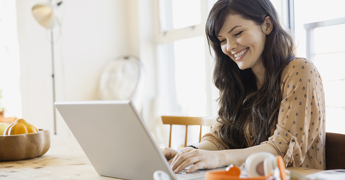 Smiling woman using laptop at table
